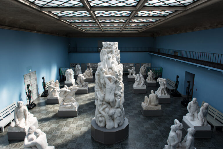 Skulpturer av Wigeland står plassert inne i et rom. Skulpturene er hvite og forestiller mennesker i ulike positurer.