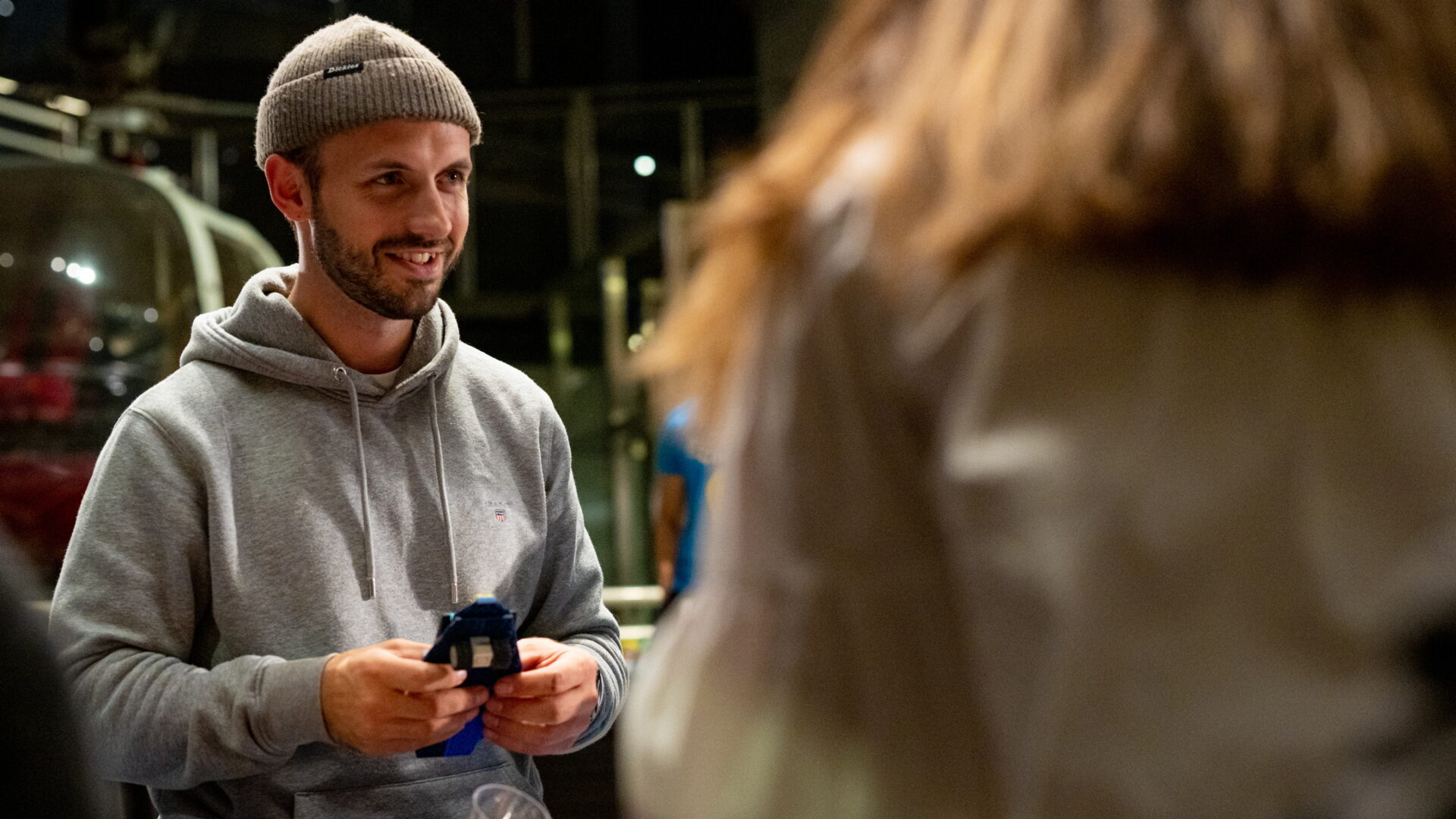Mann med grå lue og grå genser som bygger lego